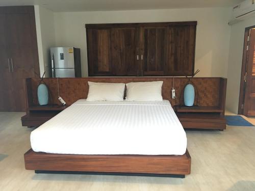 a bedroom with a large bed with white sheets at Bangpo Village in Ban Bang Po