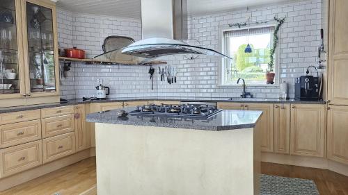 Wonderful villa with panoramic sea view SE09144 في Krommeröd: مطبخ مع جزيرة علوية موقد في مطبخ