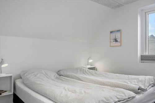 Una cama blanca en una habitación blanca con una ventana. en 1302-Thisted-Havstokken-30-1, en Thisted