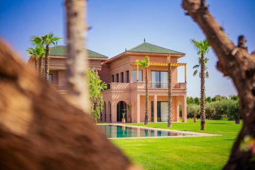 a house with a swimming pool and palm trees at Villa Jumeirah M Luxury & Spacious Pool in Marrakech