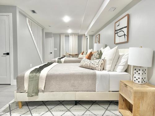 a white bedroom with a large bed with pillows at Dream Home Close to the Center of NYC in Mott Haven