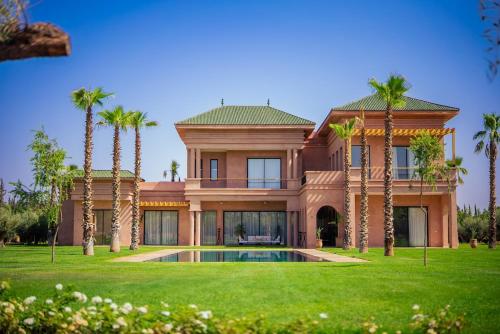 a large house with palm trees and a swimming pool at Villa Jumeirah M Luxury & Spacious Pool in Marrakech