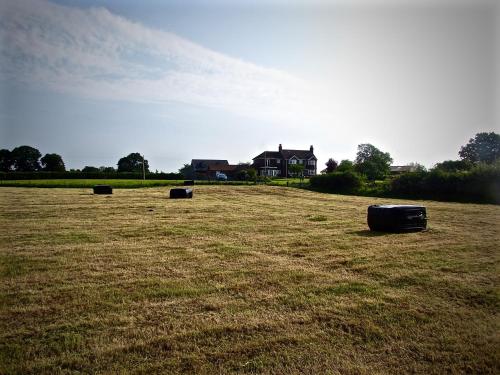 a field with three barrels sitting in the middle of it at The Moorhead Bed & Breakfast in Wem