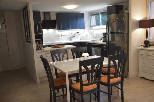 une cuisine avec une table, des chaises et un réfrigérateur dans l'établissement maison collioure, à Collioure