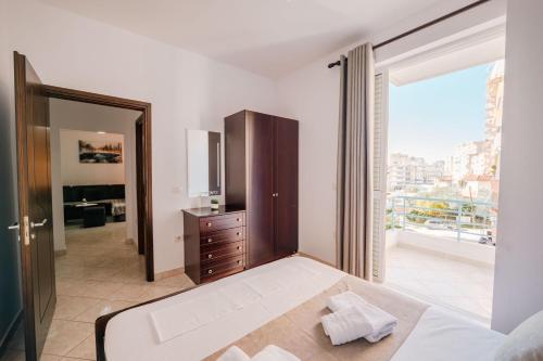 a bedroom with a large bed and a large window at ERAL Apart-Hotel & Penthouse in Sarandë