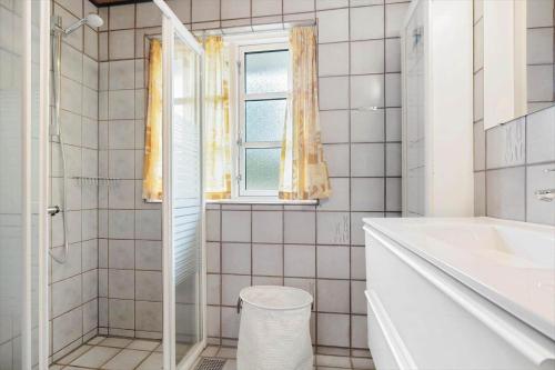 a bathroom with a tub and a sink and a window at 930-Thisted-Liusborg-Sti-28 in Torsted