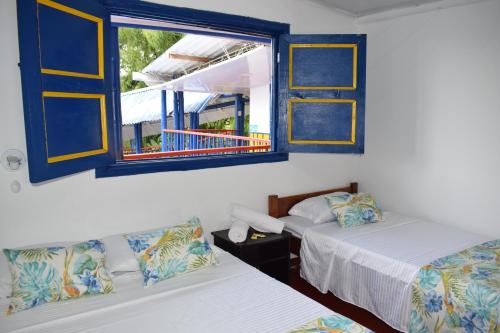 a room with two beds and a window at Finca Hotel el Edén del Quindío in Calarcá