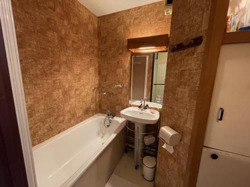 a bathroom with a tub and a sink and a bath tub at Appartement 2 pièces Griou 52 in Le Lioran