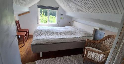 Charming house with kayaks, 300m from the sea on Orust SE09139 في Svineviken: غرفة نوم صغيرة بها سرير ونافذة