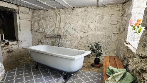 Charming house with kayaks, 300m from the sea on Orust SE09139 في Svineviken: حوض استحمام في غرفة بجدار حجري