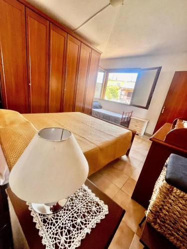 a bedroom with a bed and a lamp on a table at Casa Lucia in Villasimius