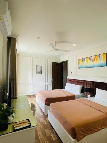 a hotel room with two beds and a television at Lynh's Villa in Cat Ba