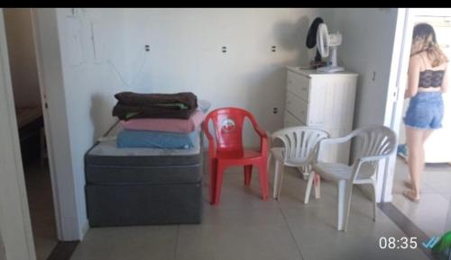 a woman walking into a room with a bed and chairs at Casa em Itapucu SC a 200mts do trapiche in Araquari