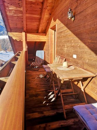 a wooden porch with a table and chairs in a cabin at Haus Vallazza in Fulpmes