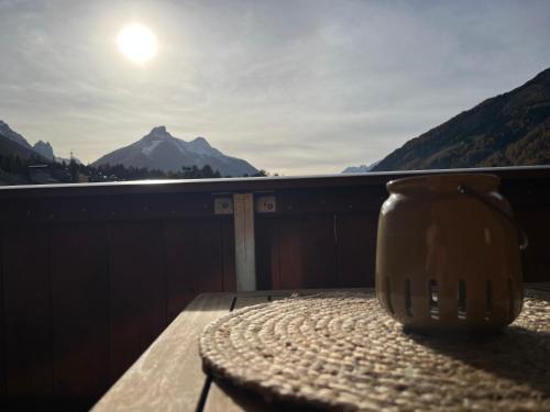 a mug sitting on a table on a balcony with the sun at Haus Vallazza in Fulpmes