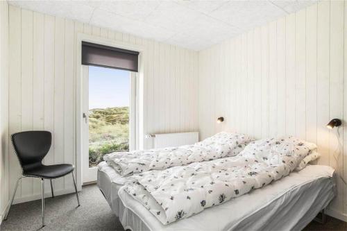 une chambre avec un lit, une chaise et une fenêtre dans l'établissement 899-Snedsted-Somaerkevej-76-B, à Snedsted
