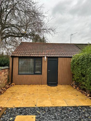a small shed with a black door and a building at Kettering Railway Lodge in Northamtonshire