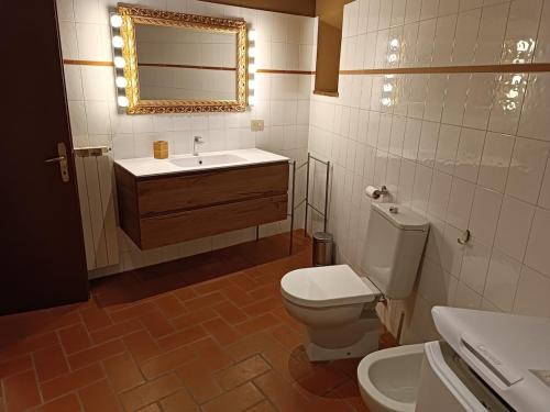 a bathroom with a toilet and a sink and a mirror at Lòrien - Elegante appartamento con vista panoramica in Lucca