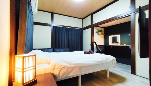 una camera da letto con un letto bianco e una scrivania di 美-yahiro- a Tokyo