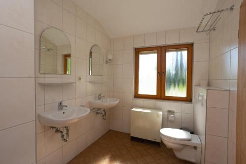 a bathroom with two sinks and a toilet at Thomsdorf Sommerland in Thomsdorf