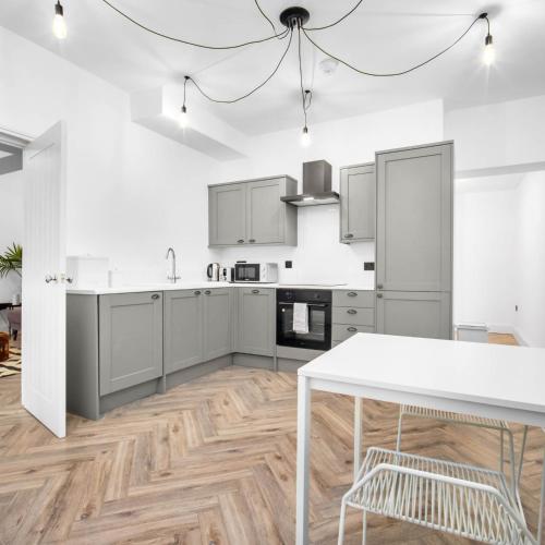 a kitchen with white cabinets and a white table at Central Wolverhampton 2-Bed Townhouse - Gated & Secure - Bedroom TV 1CO in Wolverhampton