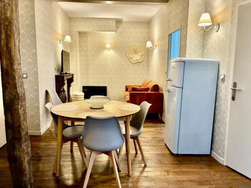 een eetkamer met een tafel en een koelkast bij La Grande escapade T12 in Troyes