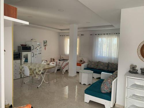 uma sala de estar com um sofá e uma mesa em App corniche hammamet em Hammamet