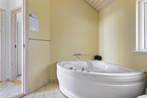 een badkamer met een groot wit bad in een kamer bij 969-Thisted-Klitstien-50 in Torsted