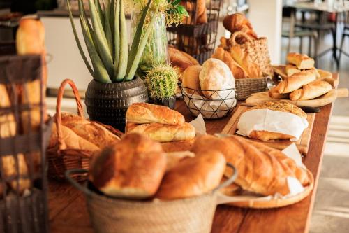 a table topped with baskets of bread and pastries at Gava Waterman Milna Resort – All Inclusive in Milna