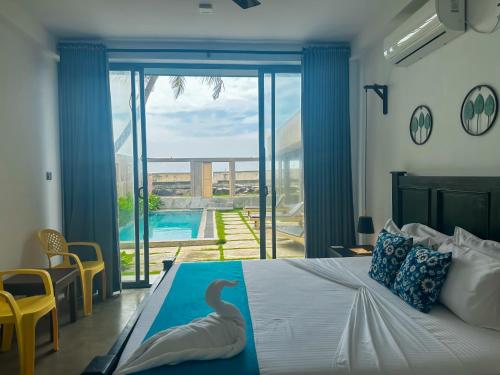 a bedroom with a bed with a swan on it at Villa Sea Queen in Ambalangoda