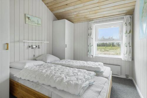 a bedroom with two beds and a window at 1052-Thisted-Bavnbak-50 in Torsted