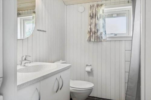a bathroom with a toilet and a sink and a window at 1052-Thisted-Bavnbak-50 in Torsted
