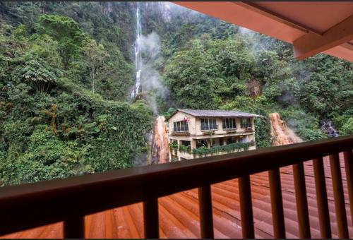 Un balcón con vista a una cascada y una casa. en Termales Santa Rosa De Cabal, en Santa Rosa de Cabal