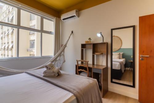 um quarto com uma cama de rede e um espelho em 1 minuto da Praia de Copacabana - PF714 no Rio de Janeiro