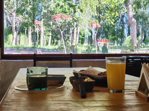a table with two glasses of beer and a plate of food at EcoMalargüe Posada & Hostel in Malargüe