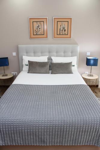 a bedroom with a large white bed with two tables at Villa Recanto de Fornelos, Gerês - Até 10 Pax in Geres