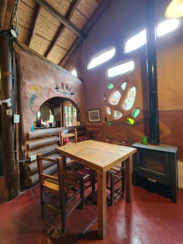 a dining room with a table and chairs and a stove at EcoMalargüe Posada & Hostel in Malargüe