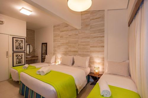 2 Betten in einem Hotelzimmer mit Grün und Weiß in der Unterkunft Pousada da Villa in Fernando de Noronha