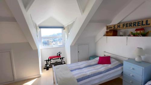 een kleine slaapkamer met een bed en een rode stoel bij Victoria Residences in St Ives