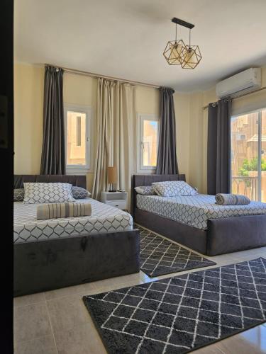 a bedroom with two beds and a chandelier at Private Villa Sea View 5BR in Ain Sokhna
