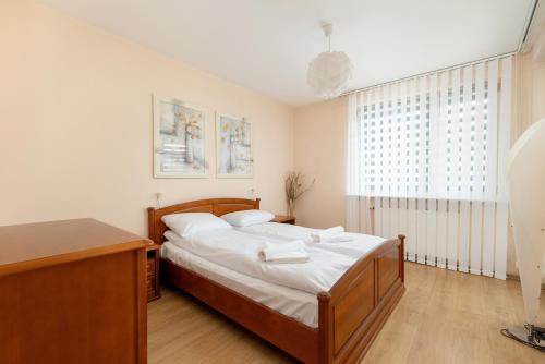 a bedroom with a large bed and a window at Central Port Giełdowa Apartment by Solarento in Kołobrzeg