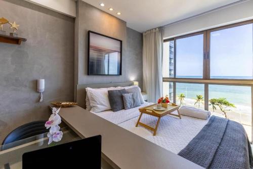 レシフェにあるBnb Flex Suitesの大きなベッドと大きな窓のある寝室