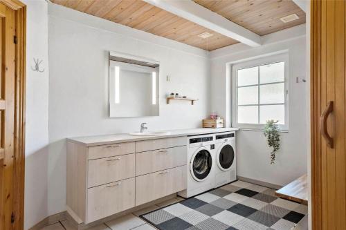 een wasruimte met een wasmachine en een gootsteen bij 456-Bedsted-Thy-Istrupvej-44 in Bedsted Thy