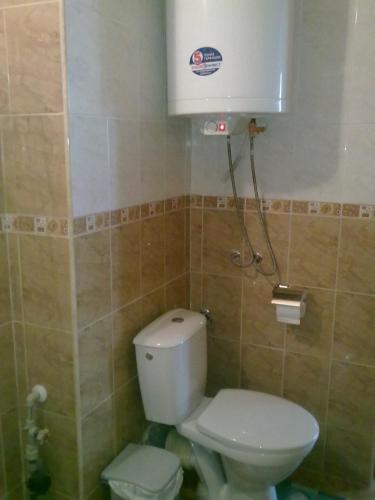 a bathroom with a toilet and a water tank at Elias Apartment in Golden Sands
