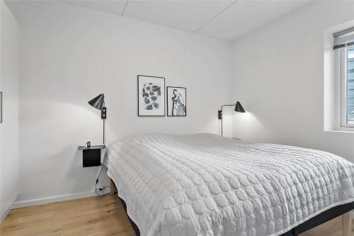 a white bedroom with a bed and two lamps at 784-Thisted-Havstokken-30-A in Thisted