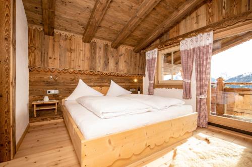 a bedroom with a bed in a room with a window at Ferienhütte Alpenherz in Alpbach