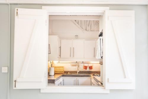 Villa Coconut Oasis في Bain Boeuf: باب مفتوح للمطبخ بدولاب بيضاء