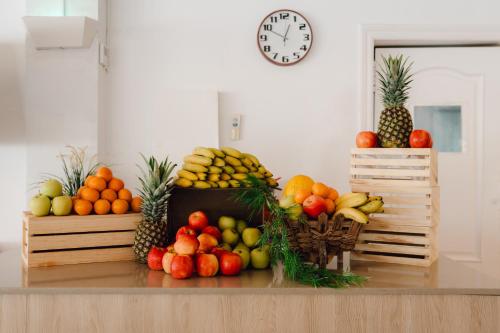 un mucchio di frutta su un tavolo con un orologio di Moon Dreams Playa Azul a Cala'n Porter