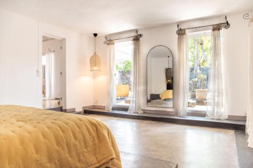 Villa Coconut Oasis في Bain Boeuf: غرفة نوم بها سرير ومرآة كبيرة