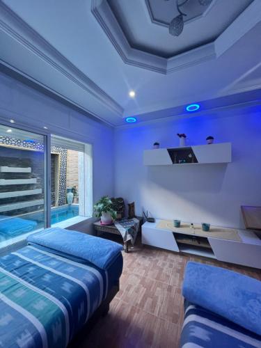 a blue room with two beds and a couch at Apartment Nazaha for families only in Tangier